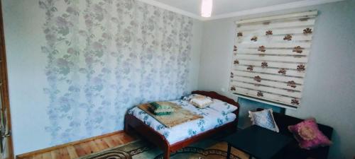 a small bedroom with a bed and a window at Samist Villa in Gabala
