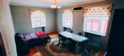salon z kanapą i stołem oraz 2 oknami w obiekcie Samist Villa w mieście Qəbələ