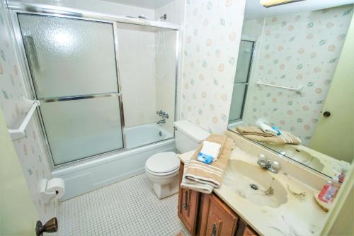 uma casa de banho com um WC, um chuveiro e um lavatório. em Sea Coast Gardens III 303 em New Smyrna Beach