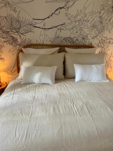 a bed with white sheets and pillows in a bedroom at Gite de La Rastelle au coeur de la nature in Savignac-de-Duras