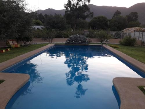 a swimming pool with blue water in a yard at Pura Vida El Molle in Vicuña