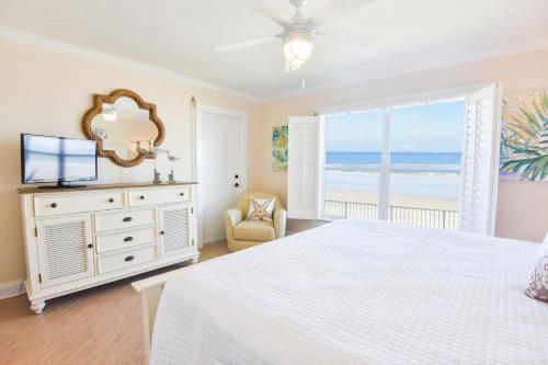 um quarto com uma cama branca e uma grande janela em Sea Coast Gardens II 105 em New Smyrna Beach