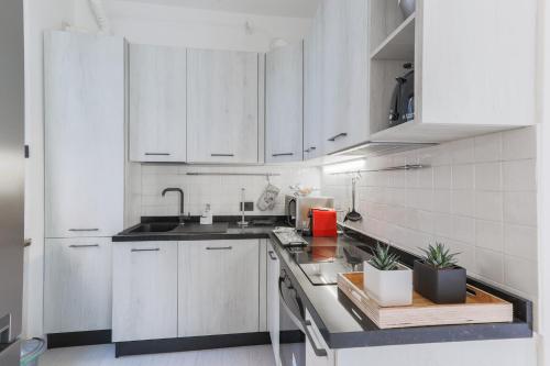 a white kitchen with white cabinets and a sink at La Dolce Vista by My Home In Como in Moltrasio