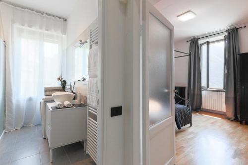 Habitación blanca con lavabo y espejo en La Dolce Vista by My Home In Como, en Moltrasio