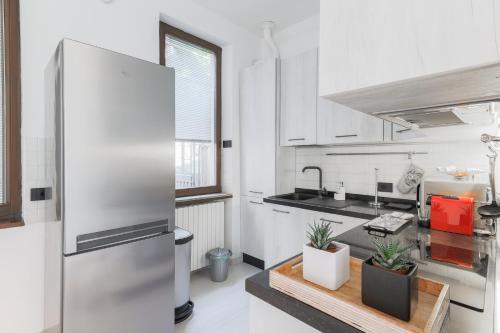 a kitchen with a stainless steel refrigerator and some plants at La Dolce Vista by My Home In Como in Moltrasio