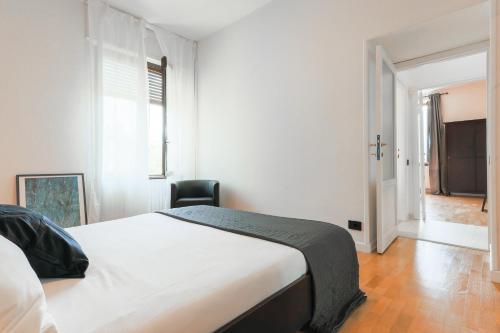 1 dormitorio blanco con 1 cama y 1 silla en La Dolce Vista by My Home In Como, en Moltrasio