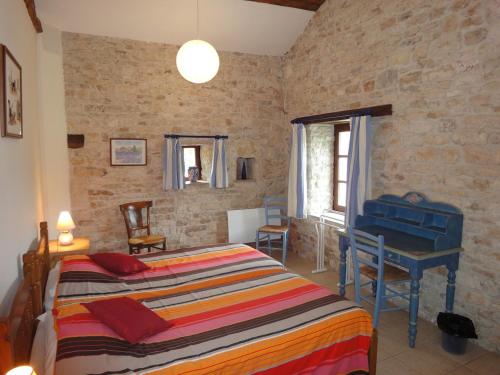 ein Schlafzimmer mit einem Bett und einem Schreibtisch. in der Unterkunft GITE DU PUITS DE LA BARRE in Sompt