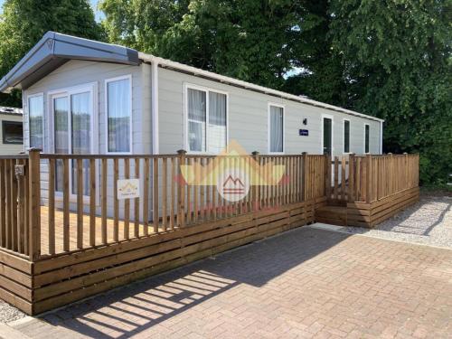 a mobile home with a wooden fence at Trekker's Rest, Brigham, Cockermouth, Cumbria in Cockermouth