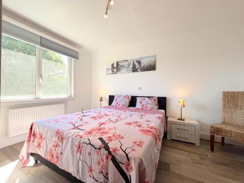 Schlafzimmer mit einem Bett mit rosa Tagesdecke in der Unterkunft Devant les Thiers in Lierneux
