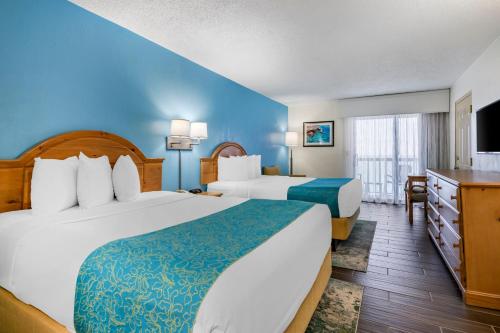 a hotel room with two beds and a television at Tropical Winds Resort Hotel in Daytona Beach
