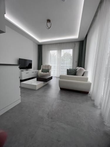 a living room with two white couches and a television at Luna Alacati in Alacati