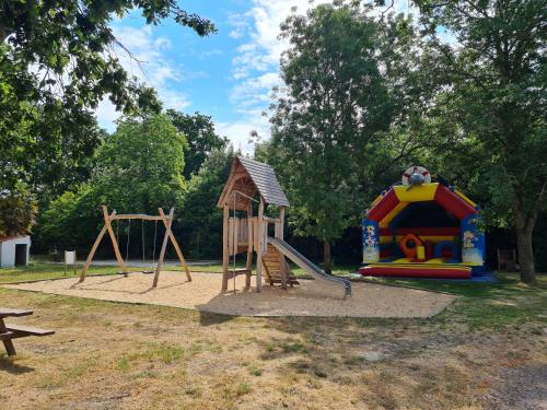 un parque infantil con tobogán y estructura de juegos en Camping Fleur d'Oleron, en Saint-Pierre-dʼOléron