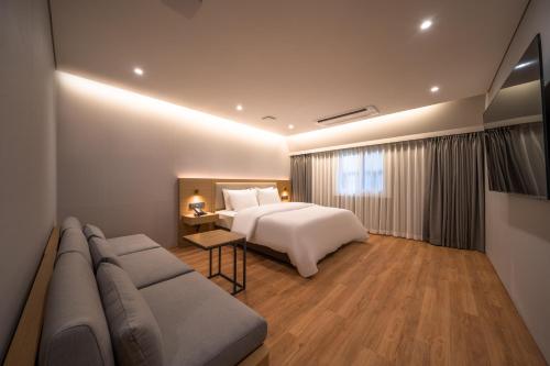 une chambre d'hôtel avec un lit et un canapé dans l'établissement Comfort inn Yeouido, à Séoul
