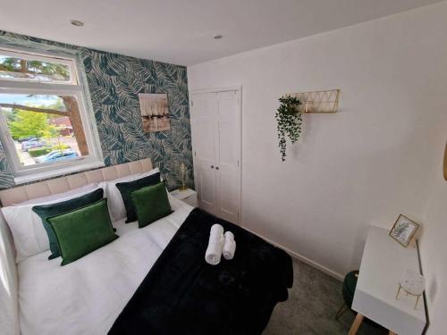 een slaapkamer met een bed met groene en witte kussens bij Two Bedroom Mansion House Apartment By AZ Luxury Stays Newmarket With Parking And WiFi in Newmarket