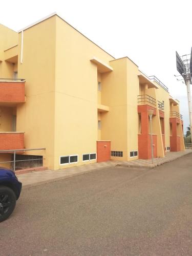 a yellow building with a windmill in the background at Bayo Lirola Hotel Balisa in Níjar