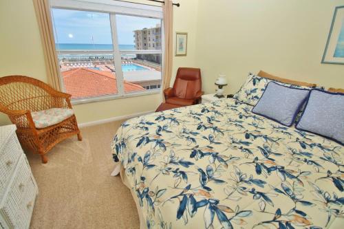 a bedroom with a bed and a view of the ocean at Sea Coast Gardens II 317 in New Smyrna Beach