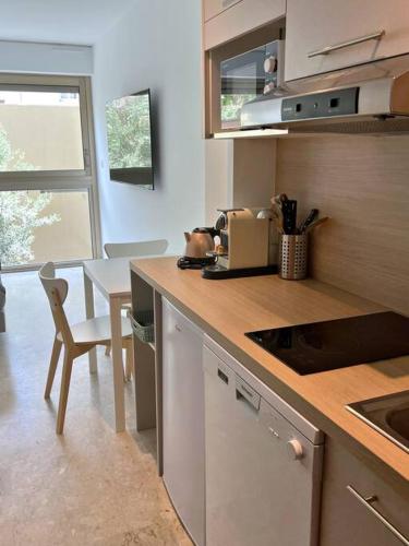 une cuisine avec un comptoir et une table avec une chaise dans l'établissement Carré d'or Studio 2, à Nice