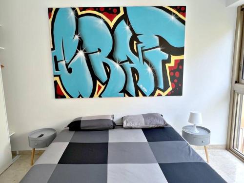 une chambre avec un lit avec un tableau sur le mur dans l'établissement Carré d'or Studio 2, à Nice