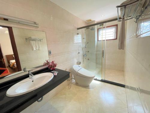 a bathroom with a toilet and a sink and a shower at Minh Đức Green Hotel Tuần Châu in Ha Long