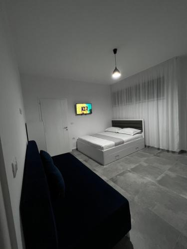 a bedroom with a bed and a tv on the wall at Vila Kledi in Shëngjin
