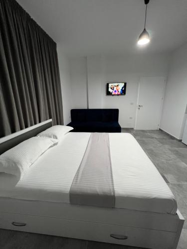 a large white bed in a room with a tv at Vila Kledi in Shëngjin