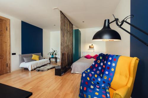 a living room with a bed and a yellow couch at Poorbaltics Studio in Liepāja