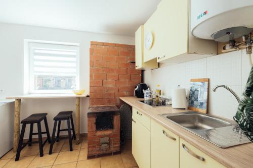 a kitchen with a sink and a brick wall at Poorbaltics Studio in Liepāja