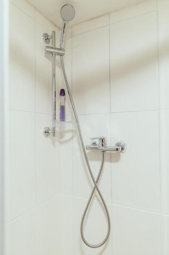 a shower with a shower head in a bathroom at Poorbaltics Studio in Liepāja