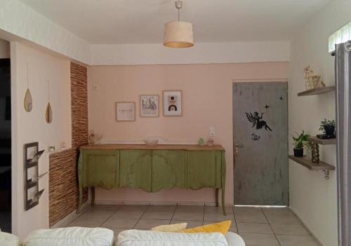 ein Wohnzimmer mit einem grünen Tisch und einem Sofa in der Unterkunft Popi's Apartment in Goníai