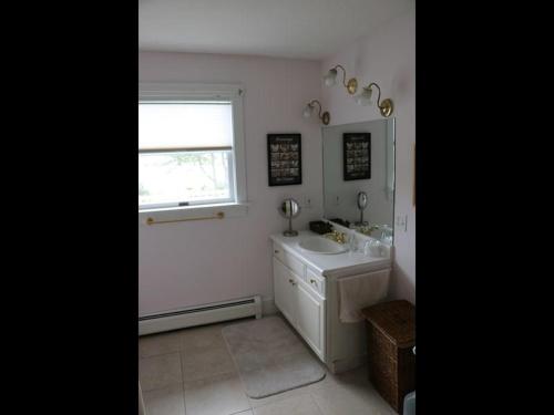 een witte badkamer met een wastafel en een raam bij Cadillac Views in Surry