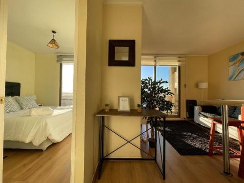 a bedroom with a bed and a table in a room at Laguna Redonda · Hermoso Departamento con Espectaculares Vistas in Concepción