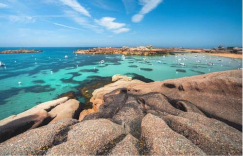 a view of a beach with rocks and the ocean at Les Portes de Tréguier - Gites de charme in Tréguier