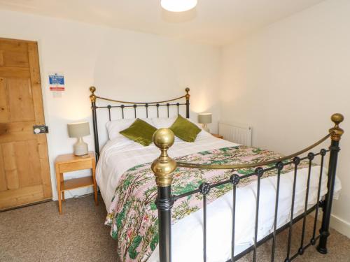 a bedroom with a bed with a metal frame at Old Wool Shop in Leyburn
