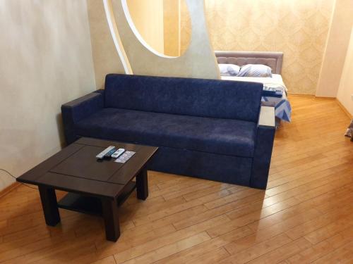 a living room with a blue couch and a coffee table at 1-комнатная квартира ВИП уровня посуточно в Ужгороде. ул.И.Франка. in Uzhhorod