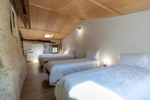 Habitación con 3 camas y sábanas blancas. en Domaine du COQ en PAT en Augerolles