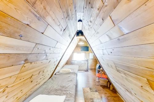 Habitación pequeña con cama en una pared de madera. en Copper Top Chalet, en Leavenworth