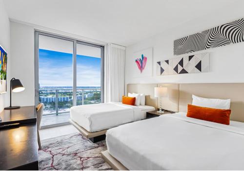 Habitación de hotel con 2 camas y ventana grande. en HYDE BEACH HOUSE #2408 THREE-BEDROOM, WATERFRONT, OCEAN AND INTERCOSTAL VIEW, ROOFTOP POOL, 5 MiN WALK TO BEACH en Hollywood