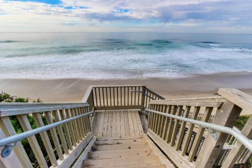 a stairway to the beach with the ocean in the background at Olivia's Rose in Lincoln City