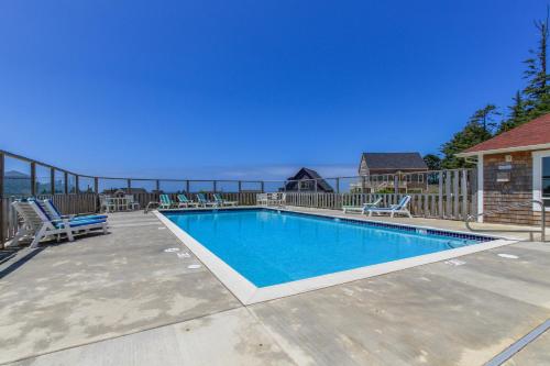 a swimming pool on a patio with chairs around it at Olivia's Rose in Lincoln City