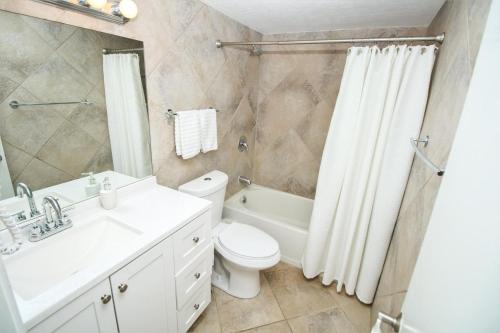 een badkamer met een wastafel, een toilet en een douche bij Sea Coast Gardens III 215 in New Smyrna Beach