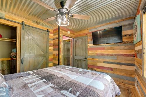 a bedroom with a bed and a ceiling fan at Lakeside Cabin with Fire Pit Near Pine Point Park! in Holcombe