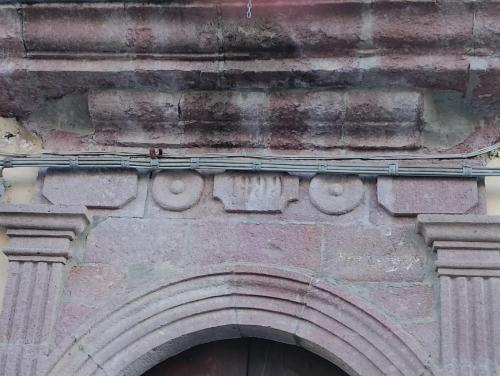 a stone building with an arch over a door at B&b Ammentos in Magomadas