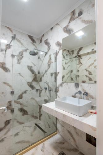 a bathroom with a sink and a shower at Hotel Simona Halep - Mamaia Nord in Mamaia Sat/Năvodari