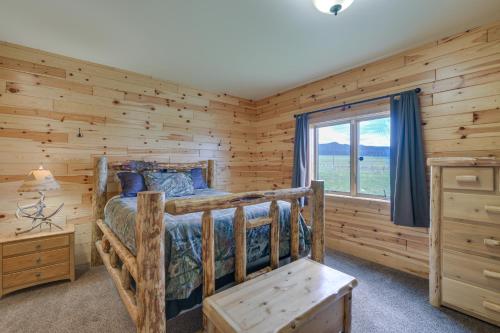 Cette cabane en rondins comprend un lit et une fenêtre. dans l'établissement Rural Divide Cabin with Mountain Views!, à Divide
