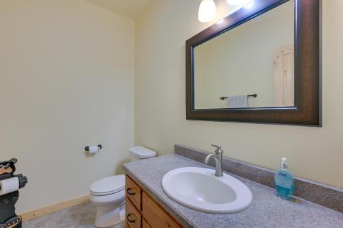 La salle de bains est pourvue d'un lavabo, de toilettes et d'un miroir. dans l'établissement Rural Divide Cabin with Mountain Views!, à Divide