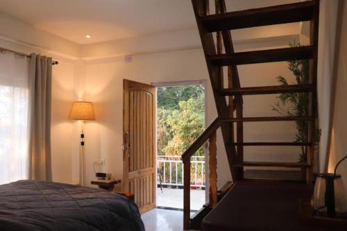 1 dormitorio con escalera de caracol y 1 cama en K - Den Homestay & Cafe en Kurseong