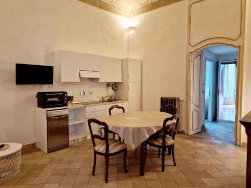 une cuisine avec une table et des chaises dans une pièce dans l'établissement Elegante appartamento in centro., à Turin