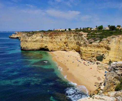 a group of people on a beach near the ocean at T0 Junto a Praia de Vale Centeanes / Carvoeiro in Lagoa