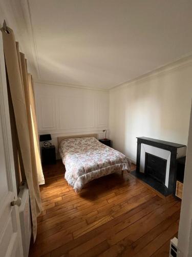 une chambre avec un lit et une cheminée dans l'établissement Cosy appartement paris à deux pas, à Courbevoie