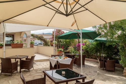 un patio extérieur avec des tables et des parasols dans l'établissement Rooms Tavolara, à San Teodoro